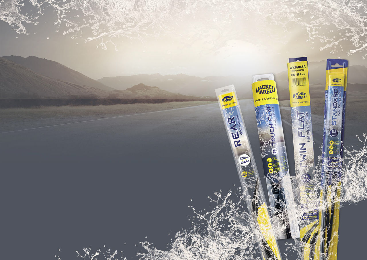 Four types of Magneti Marelli Parts & Services wiper blades in their packaging, with a mountain road in the background and water droplets simulating a view from a clean car windshield.